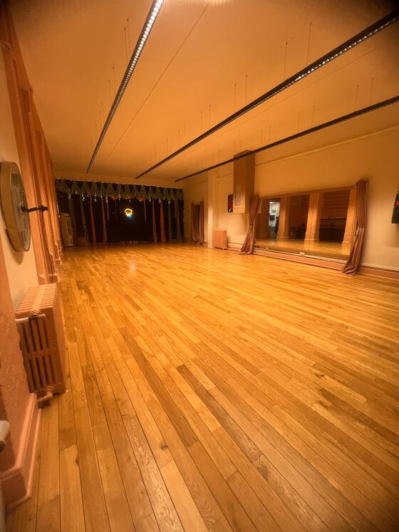 La salle dans sa longueur vers la scène, les miroirs le long du mur